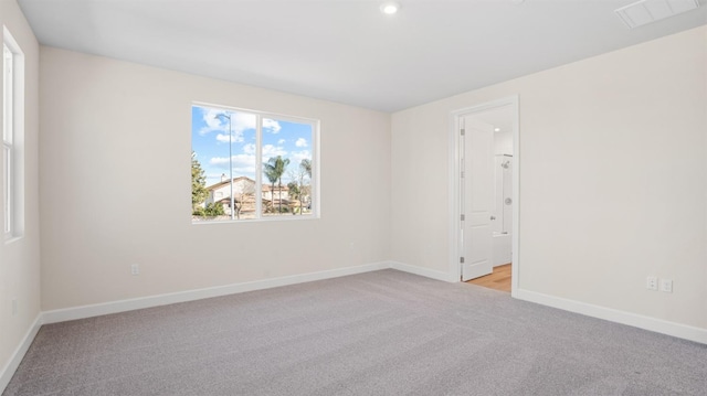 empty room with recessed lighting, baseboards, visible vents, and light carpet