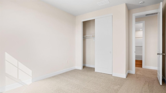 unfurnished bedroom featuring a closet, visible vents, baseboards, and carpet