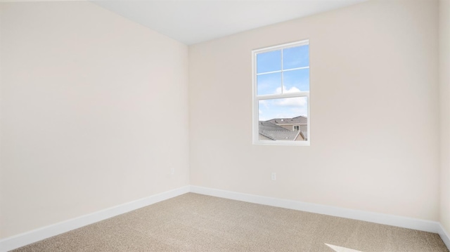 unfurnished room featuring light colored carpet and baseboards