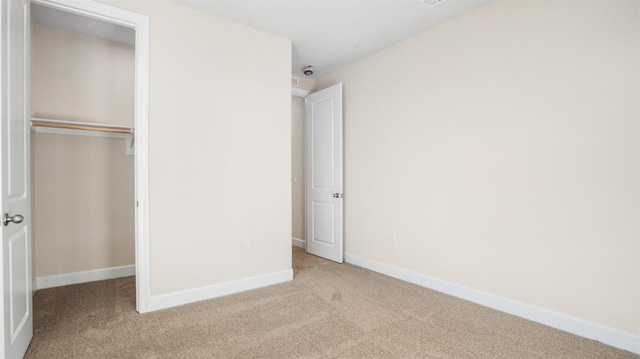 unfurnished bedroom with a closet, baseboards, and carpet