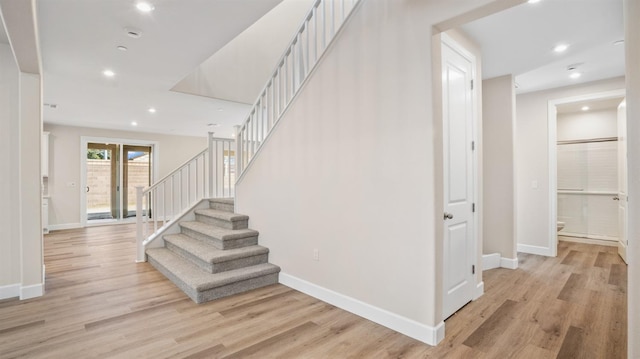 stairway with recessed lighting, baseboards, and wood finished floors