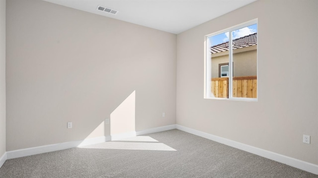 carpeted empty room featuring visible vents and baseboards