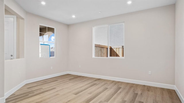 spare room featuring recessed lighting, baseboards, and wood finished floors