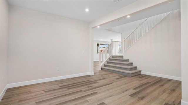 interior space featuring wood finished floors, recessed lighting, baseboards, and stairway