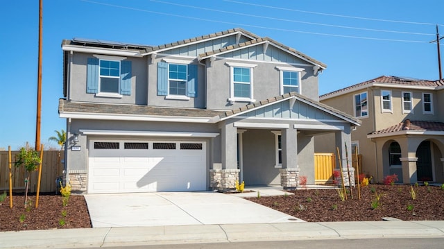 craftsman inspired home with fence, driveway, a garage, board and batten siding, and roof mounted solar panels