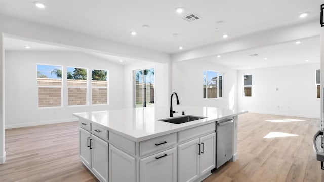 kitchen featuring visible vents, a sink, plenty of natural light, open floor plan, and dishwasher