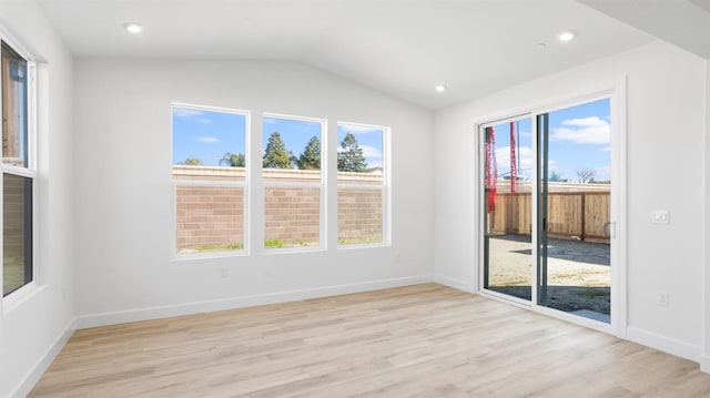 empty room featuring lofted ceiling, light wood-style flooring, recessed lighting, and baseboards