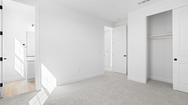 unfurnished bedroom featuring visible vents, baseboards, carpet, and a closet