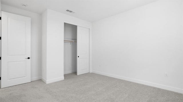 unfurnished bedroom with baseboards, visible vents, carpet floors, and a closet