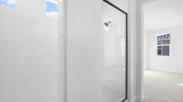 bathroom with a stall shower and baseboards