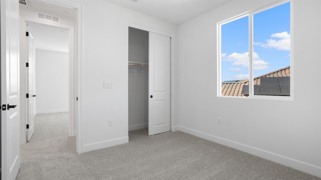 unfurnished bedroom with a closet, baseboards, visible vents, and carpet floors