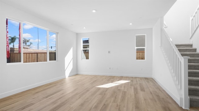 unfurnished living room with stairs, light wood-style flooring, recessed lighting, and baseboards