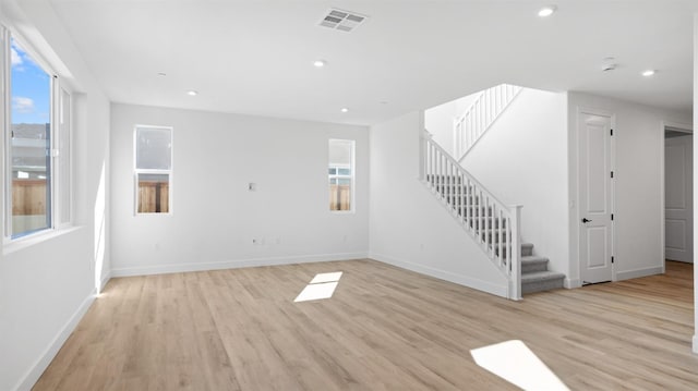 unfurnished living room with visible vents, recessed lighting, stairway, light wood-style floors, and baseboards