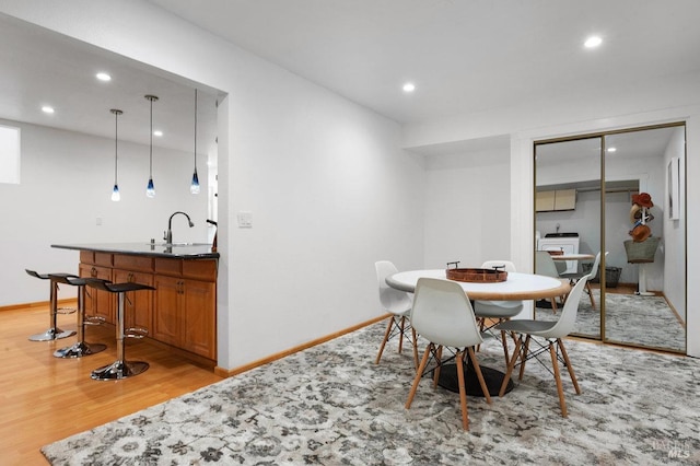 dining area with light hardwood / wood-style floors and indoor wet bar