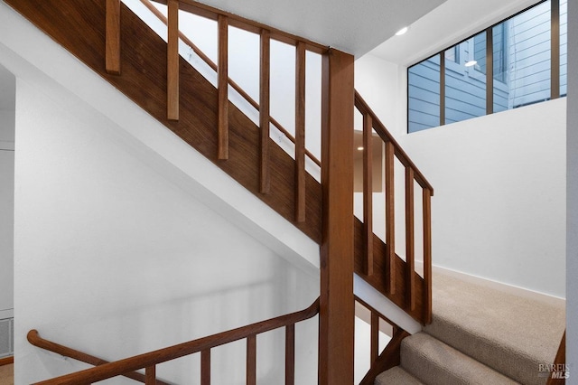 stairs featuring carpet flooring