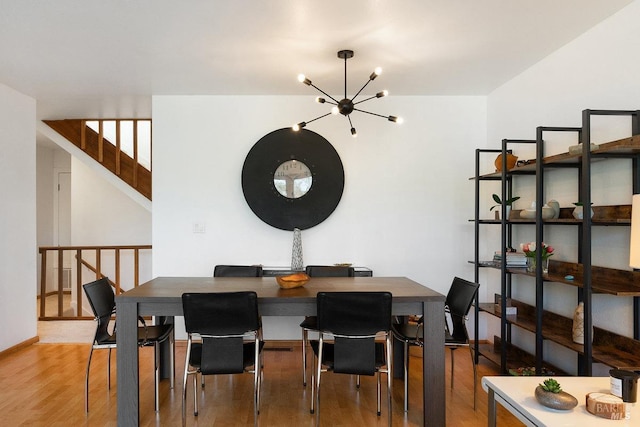 dining area featuring hardwood / wood-style floors and a notable chandelier