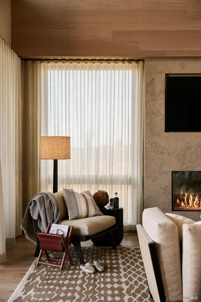 living area with a high end fireplace and wood finished floors