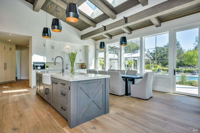 kitchen with light hardwood / wood-style flooring, plenty of natural light, a skylight, and pendant lighting