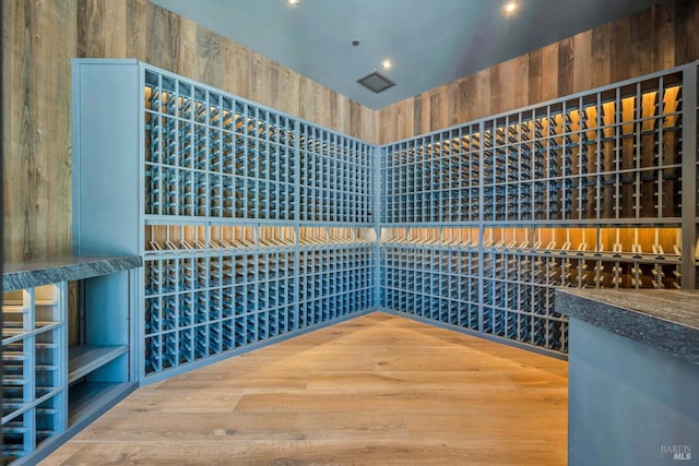 wine cellar featuring recessed lighting, a high ceiling, and wood finished floors