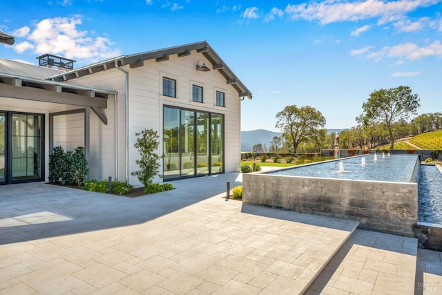 exterior space featuring a mountain view and a patio area