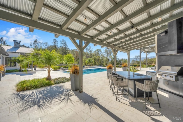 view of patio / terrace featuring area for grilling, an outdoor bar, and a pergola