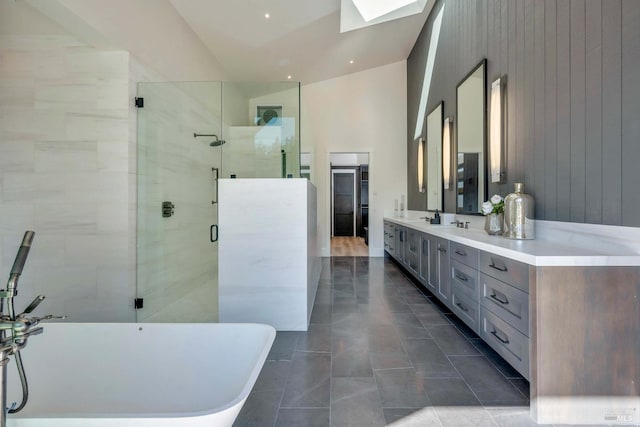 bathroom with a skylight, shower with separate bathtub, wooden walls, vanity, and tile patterned flooring