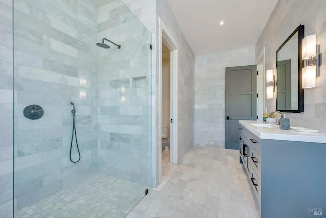 full bath with double vanity, a sink, a tile shower, and toilet