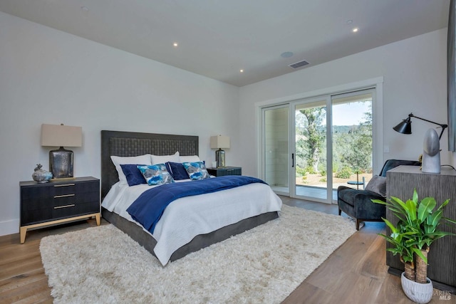 bedroom featuring recessed lighting, wood finished floors, visible vents, and access to exterior