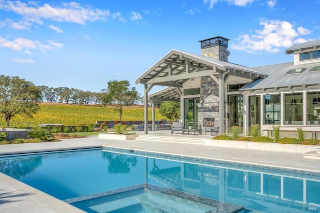 view of pool with a patio, a pool with connected hot tub, a fireplace, and a gazebo