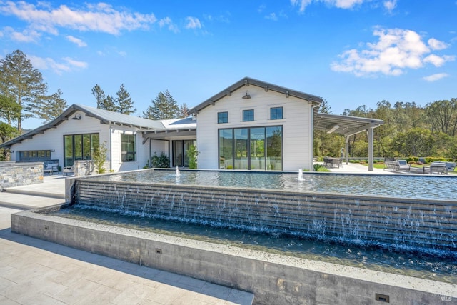 rear view of property with a patio area, pool water feature, and a pergola