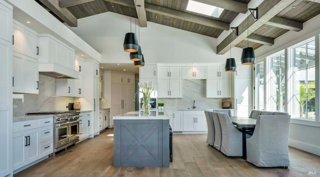 kitchen with white cabinets, beam ceiling, pendant lighting, and double oven range