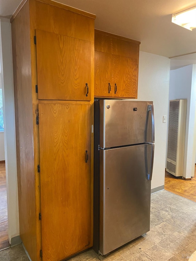 kitchen with light hardwood / wood-style flooring and stainless steel refrigerator