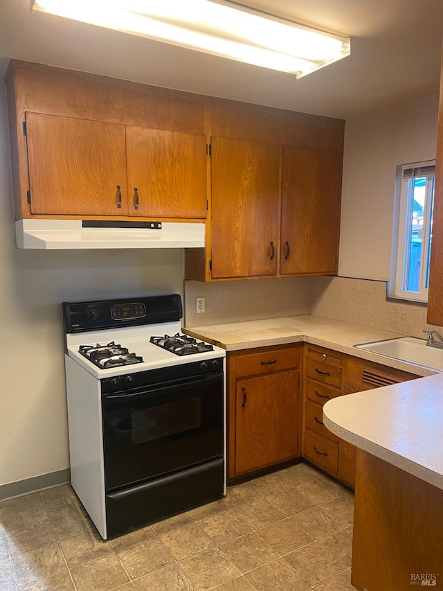 kitchen with white gas range oven and sink