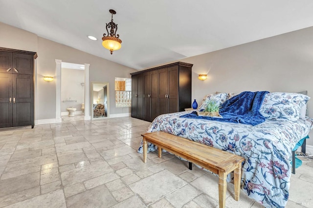 bedroom with connected bathroom and vaulted ceiling