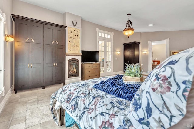 bedroom featuring french doors and a fireplace