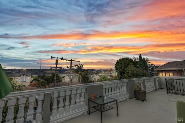 patio terrace at dusk featuring a balcony