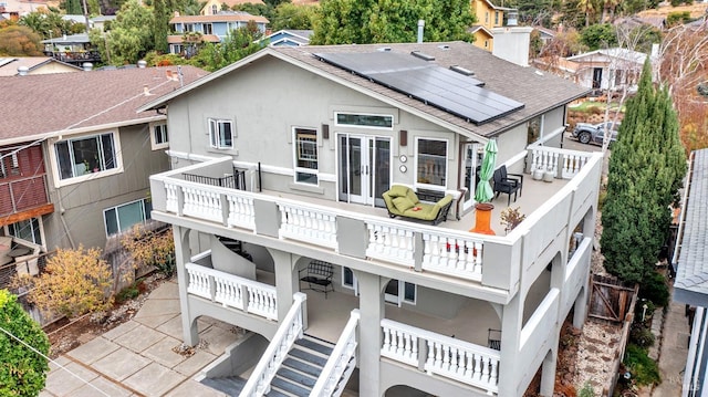 back of house featuring a patio area, solar panels, and a balcony