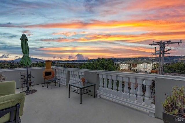 balcony at dusk featuring a mountain view