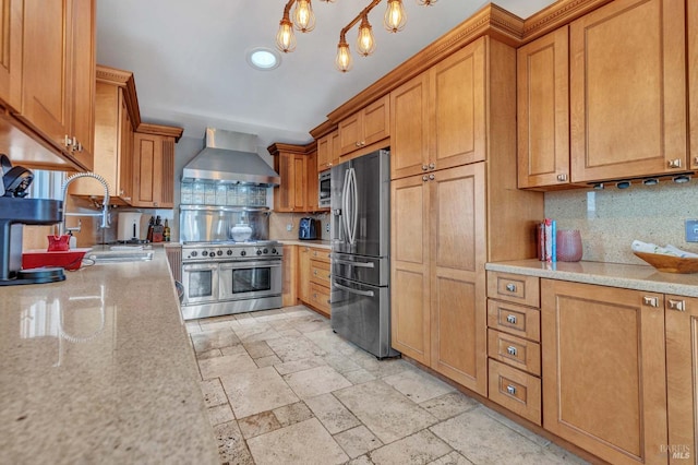 kitchen with wall chimney range hood, decorative backsplash, appliances with stainless steel finishes, an inviting chandelier, and sink