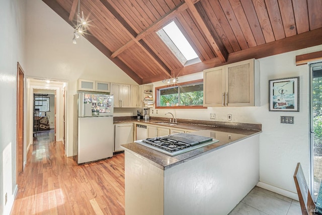 kitchen with white appliances, a skylight, sink, wood ceiling, and light hardwood / wood-style floors