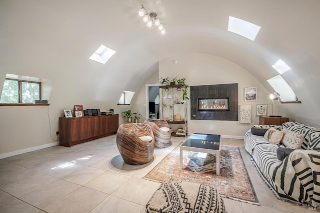 living room with light tile patterned floors, an inviting chandelier, vaulted ceiling, and a fireplace