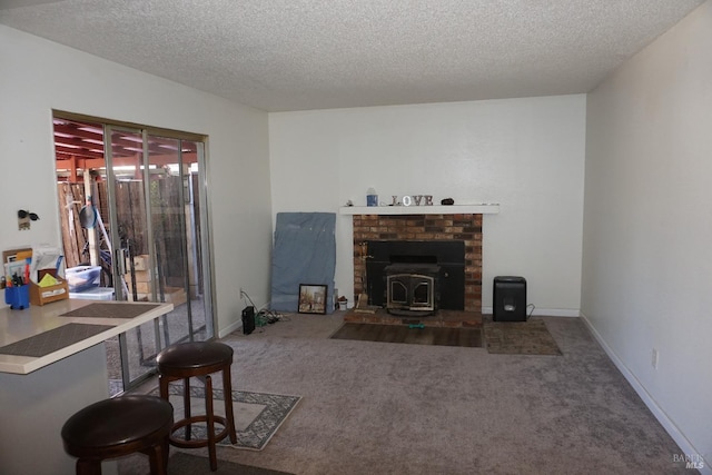 living room featuring carpet, a wood stove, and a textured ceiling