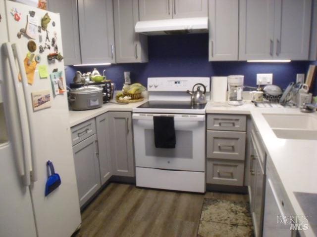 kitchen featuring gray cabinets, sink, white appliances, and dark hardwood / wood-style flooring