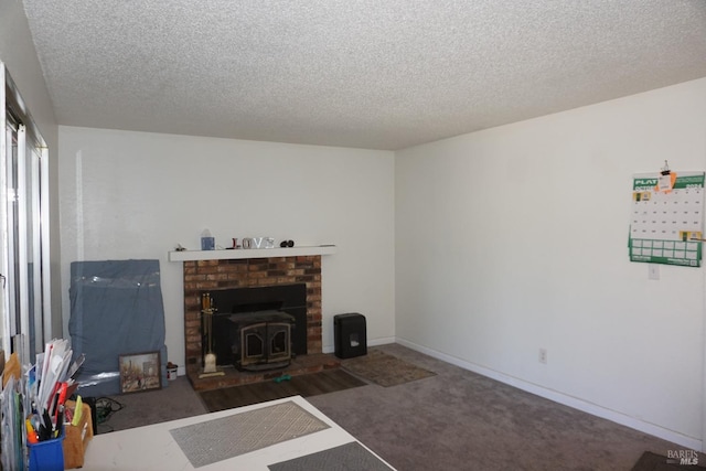 living room with a wood stove, a textured ceiling, and dark colored carpet