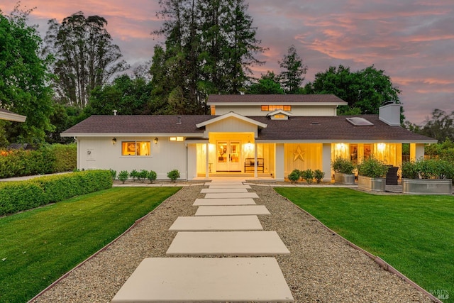 view of front of home with french doors and a lawn