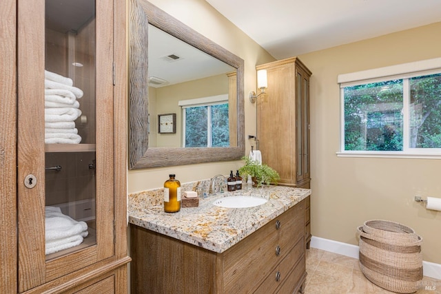 bathroom with vanity, a healthy amount of sunlight, and tile patterned floors