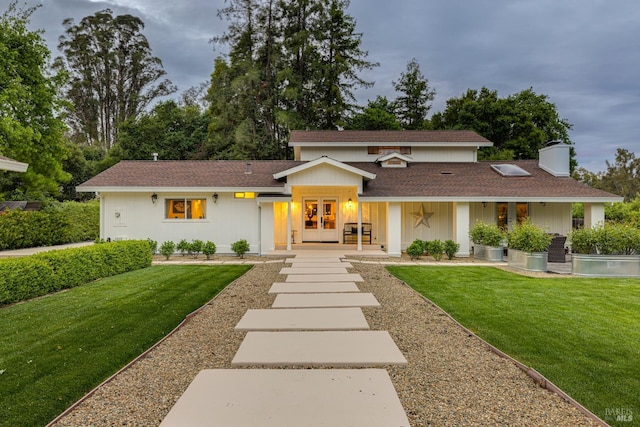 view of front facade with french doors, a front yard, and a swimming pool