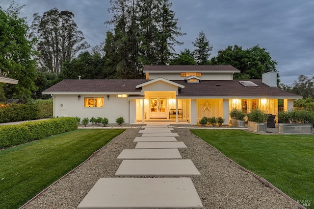 view of front of home with french doors and a yard