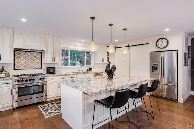 kitchen with white cabinetry, dark hardwood / wood-style floors, appliances with stainless steel finishes, and a kitchen island