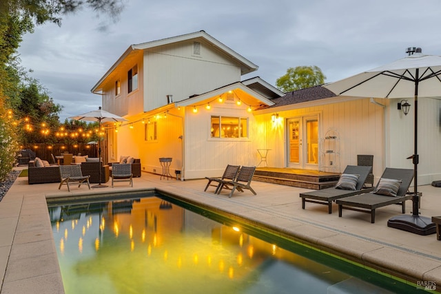 view of pool featuring a patio, an outdoor living space, and french doors